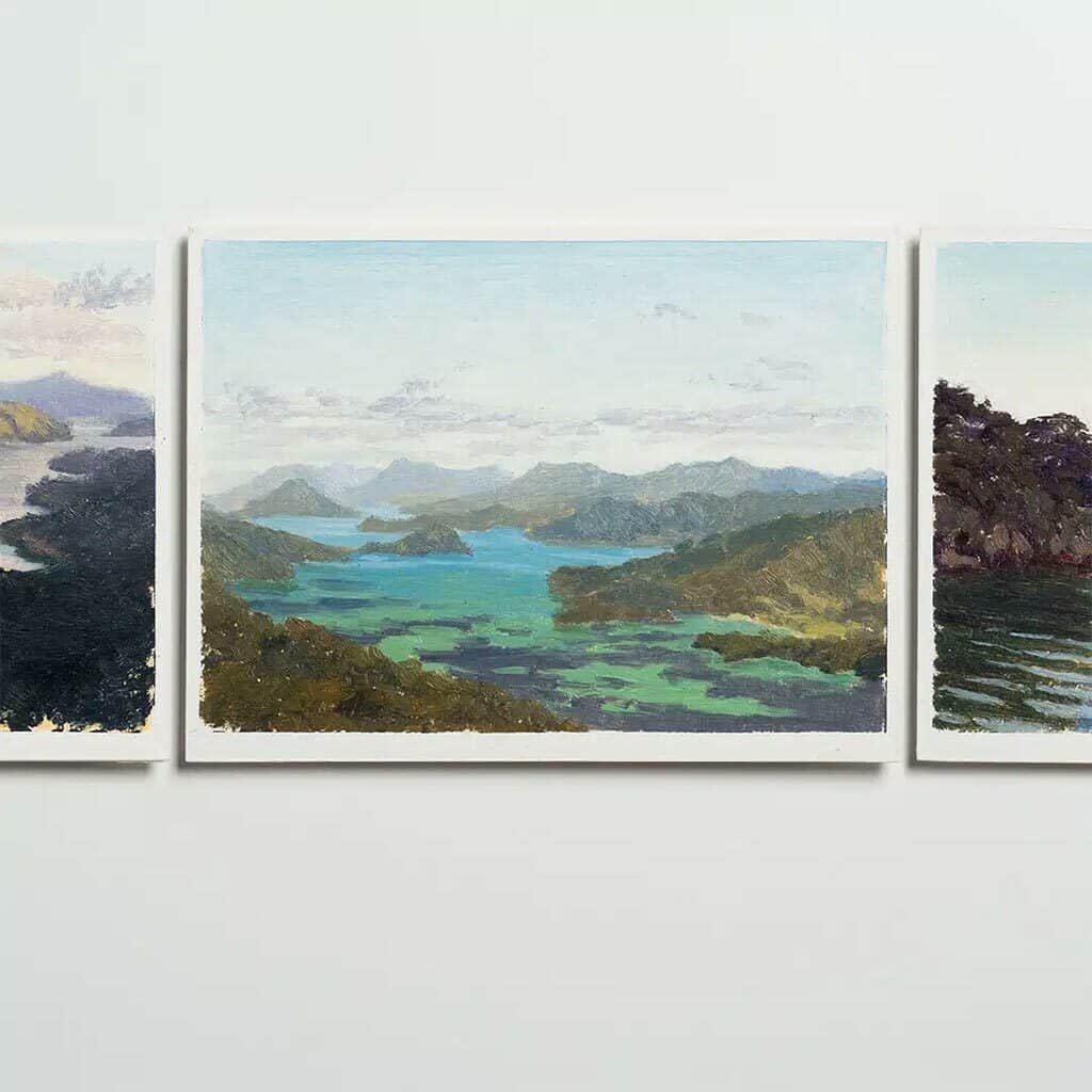 landscape painting of hills and ocean, hanging on gallery wall alongside other paintings