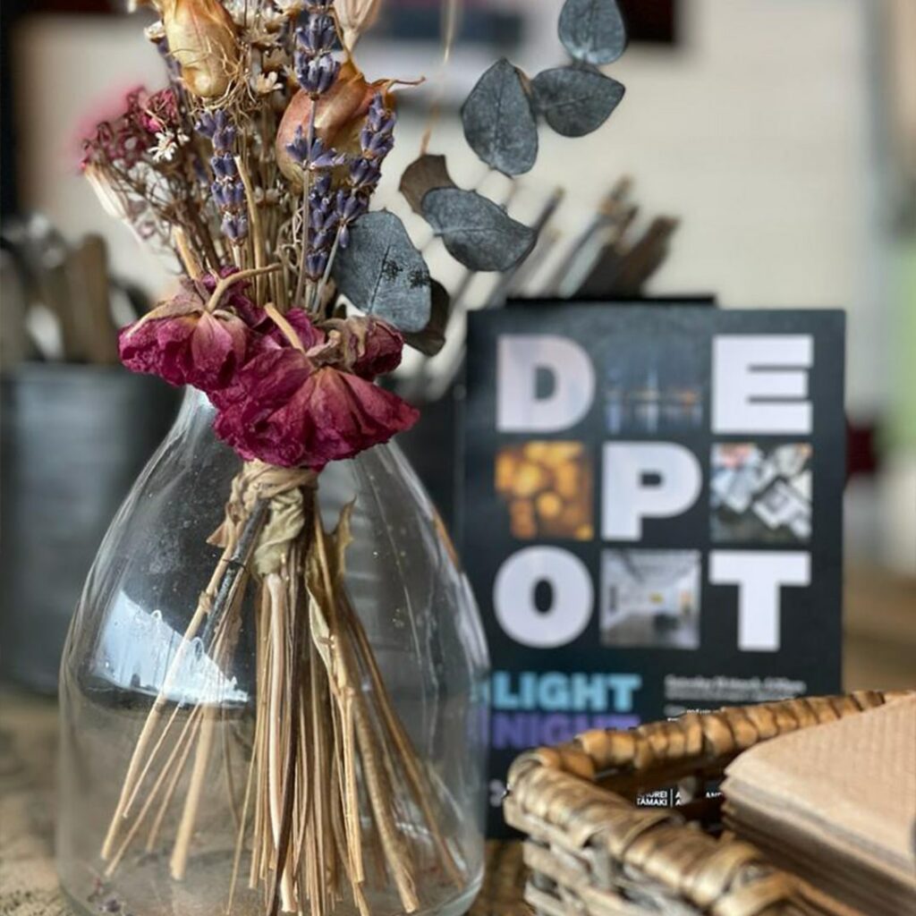 Photo of flowers and DEPOT's Light Night flyer on the Cenral Gallery front desk.